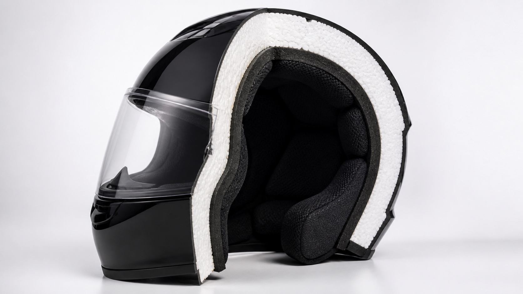 ヘルメットの断面カットモデル。外側の硬い帽体、白い発泡ライナー、内側の布の内装という3層構造が見えている